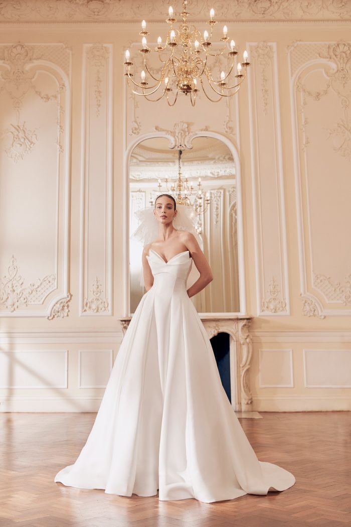 Mikado satin bridal gown with peaked neckline and textured fabric, by Ellis. Bridal Shop Northallerton