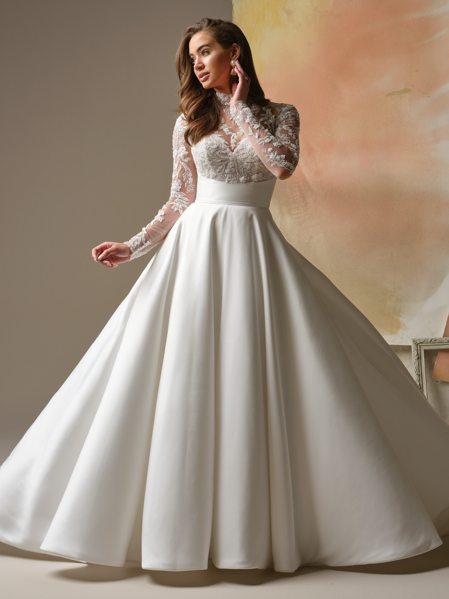 Maggie Sottero Trinity is a regal lace bodice mock neck A-line wedding dress.